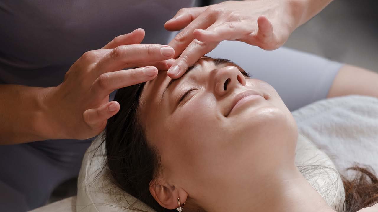 face and head massage at spa Mid adult woman enjoying in her relaxing massage